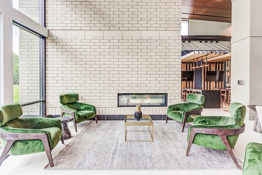 a living room with green chairs and a fireplace
