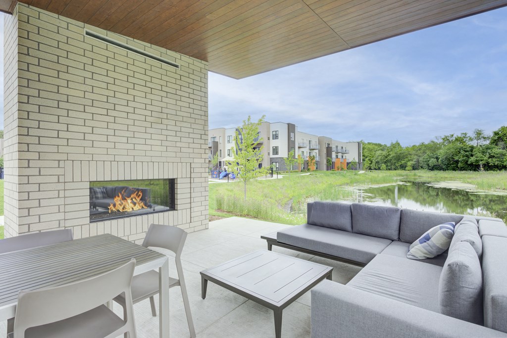 a patio with a couch and a table and a fireplace