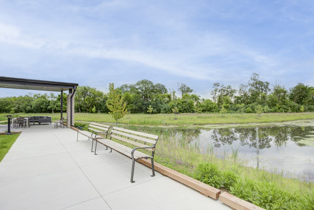 a pavilion with benches next to a body of water