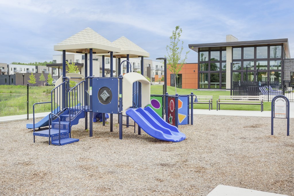 a playground with a swing set and slides at a park