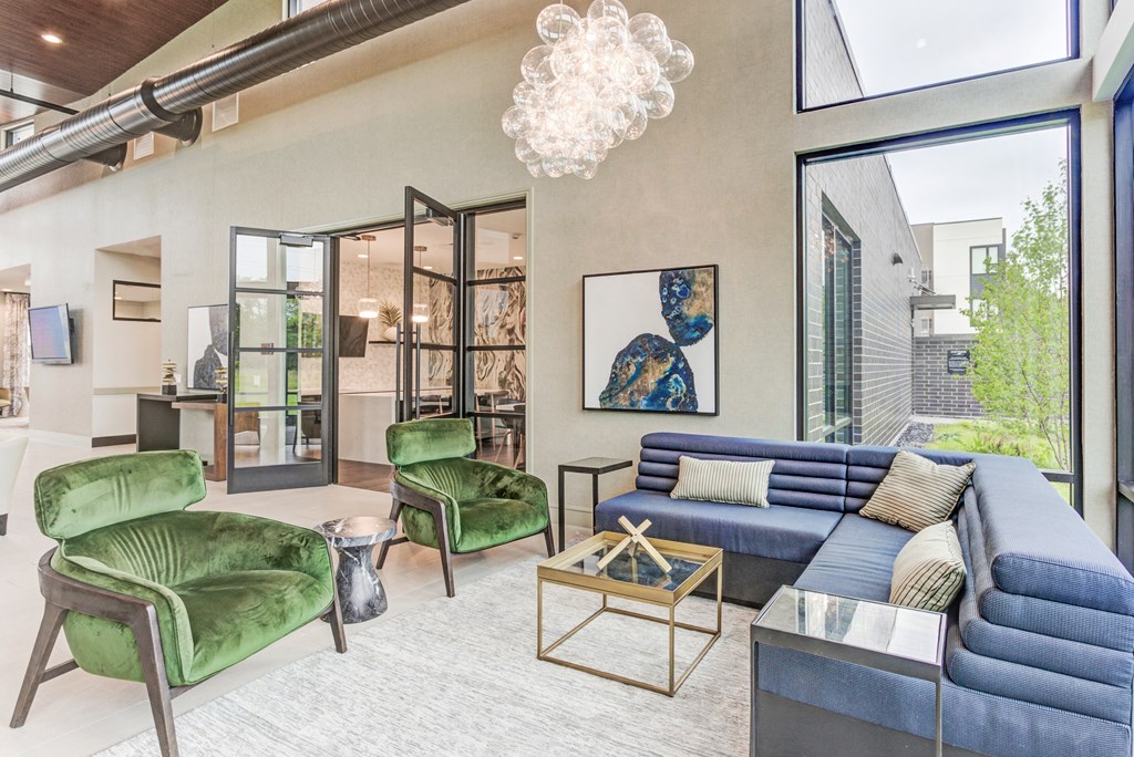 a living room with a blue couch and green chairs