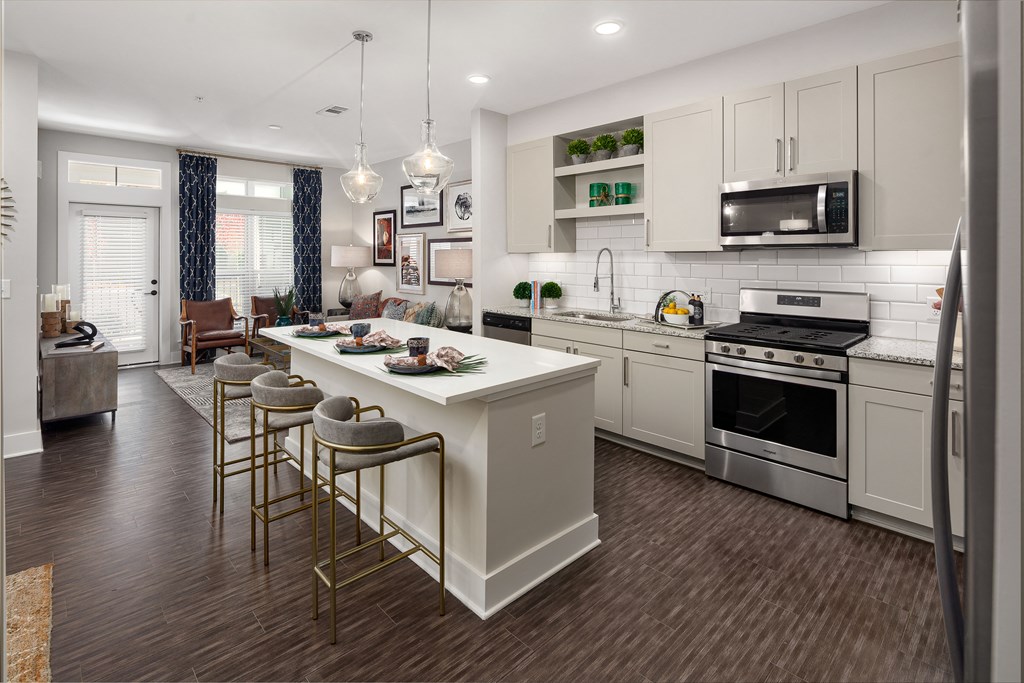 A kitchen with a white island and stainless steel appliances.