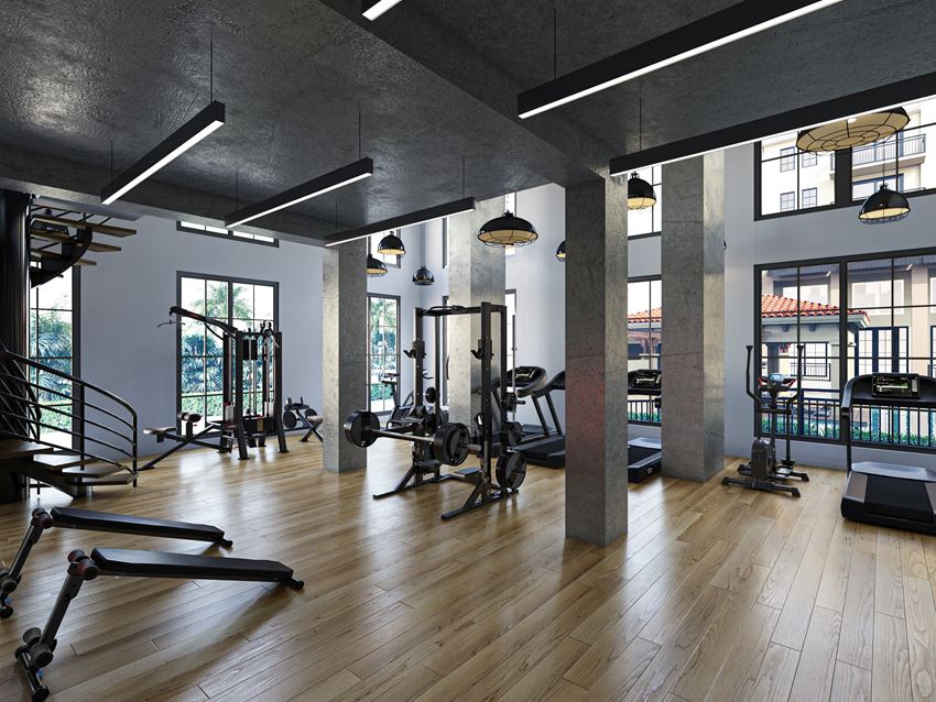 a gym with weights and exercise equipment in a large room with windows