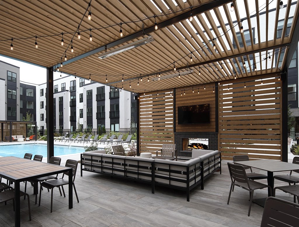 a patio with a pool and tables and a fireplace