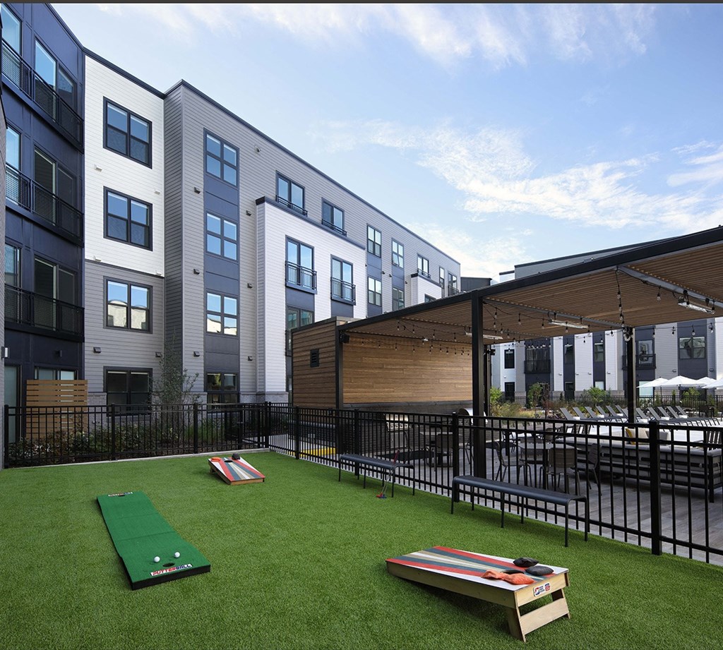 a rendering of a yard with two shuffle boards in front of apartment buildings