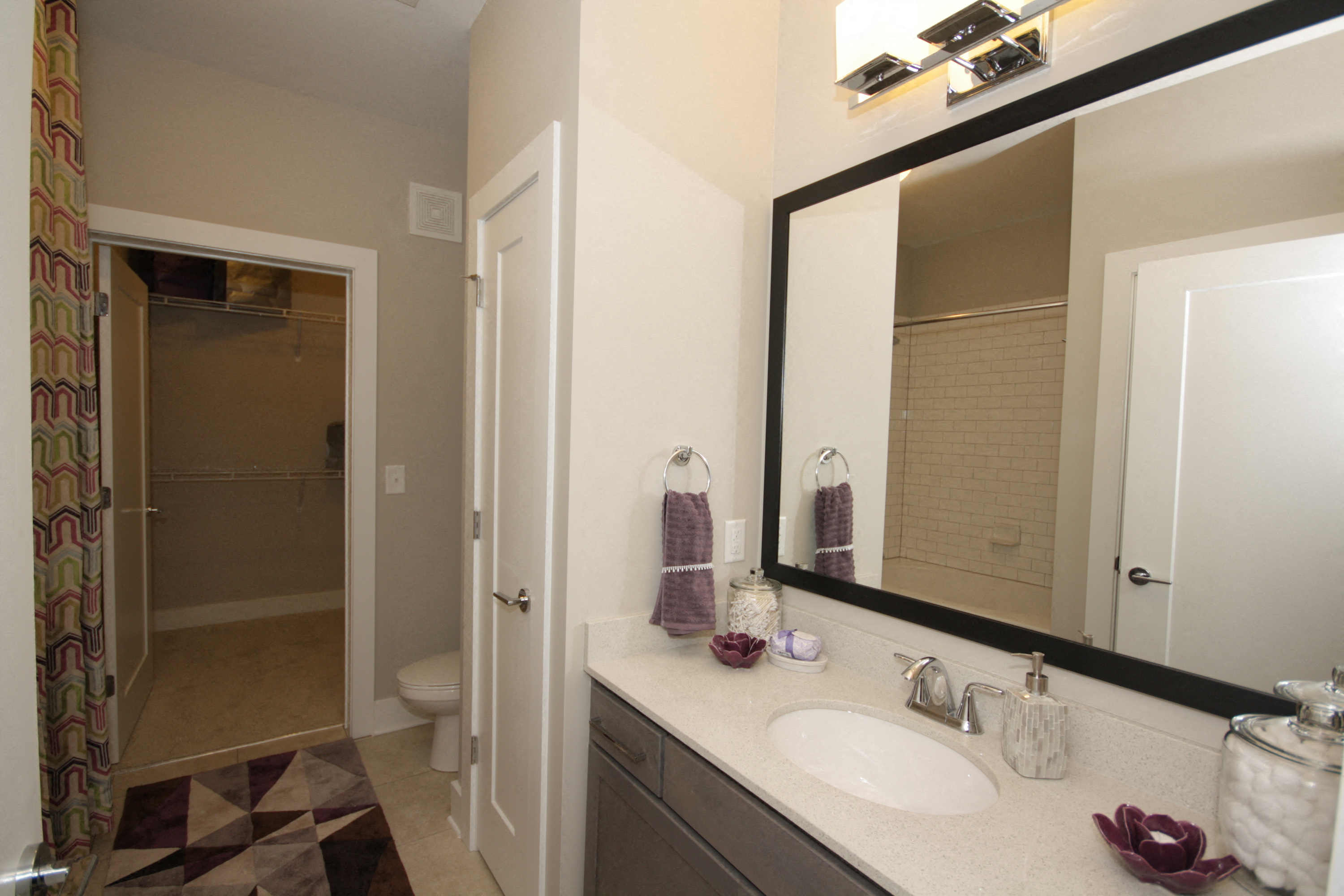 Bathroom with large mirror and a walk-in closet. 