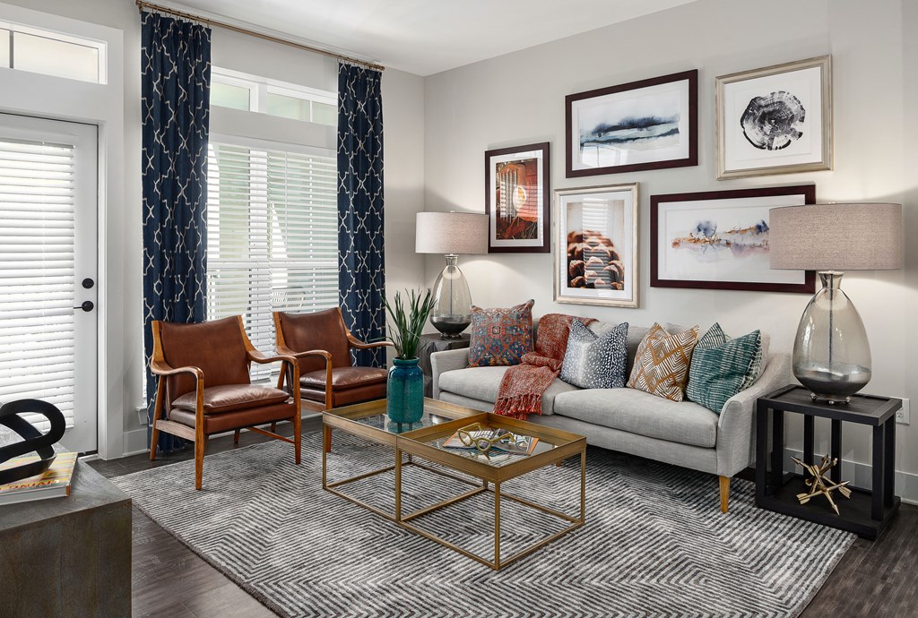 A living room with a grey couch, a coffee table, and a lamp.