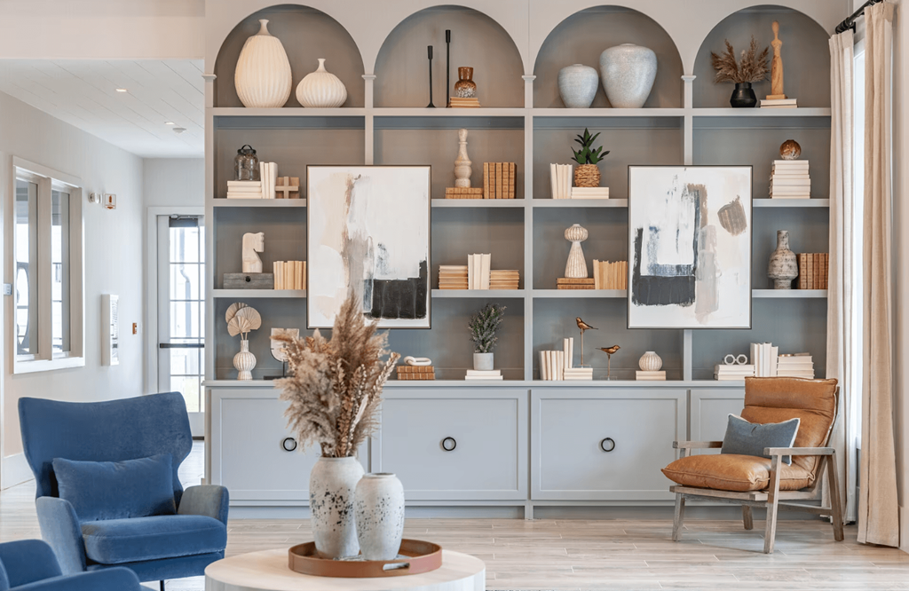 a living room with blue furniture and a shelf with vases