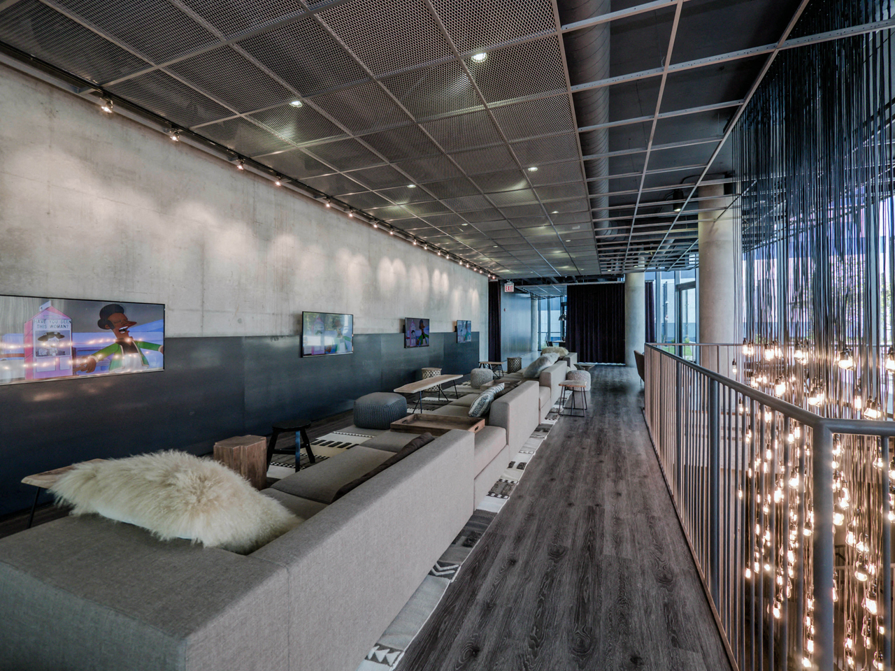 Penhouse lounge with multiple grey couches and televisions at The Parker in Chicago, IL