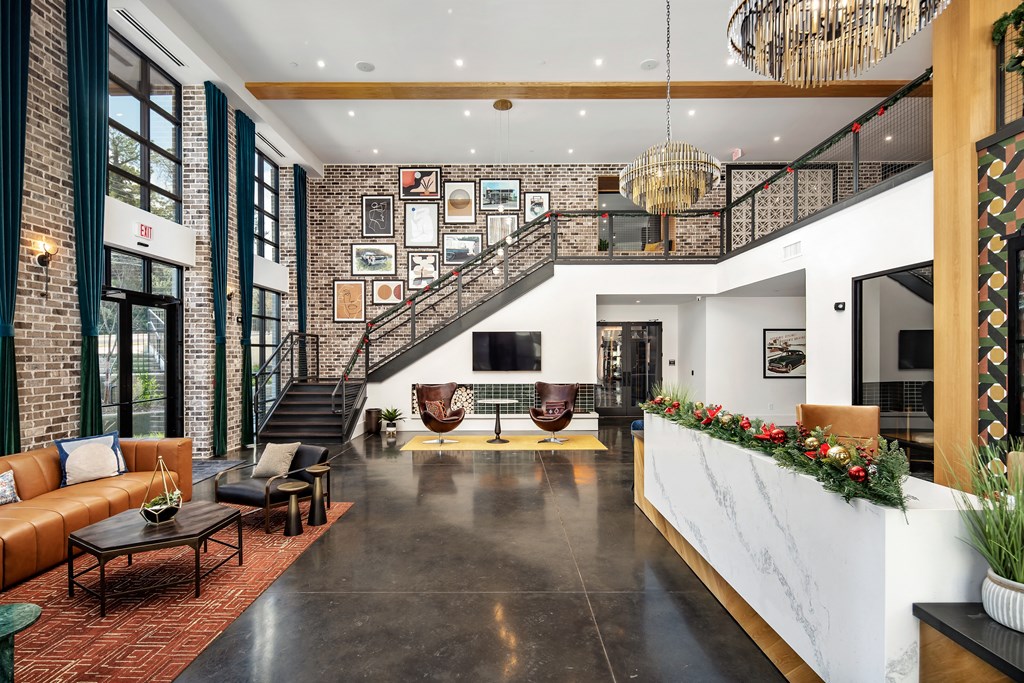 the lobby of a hotel with a large reception area and a staircase
