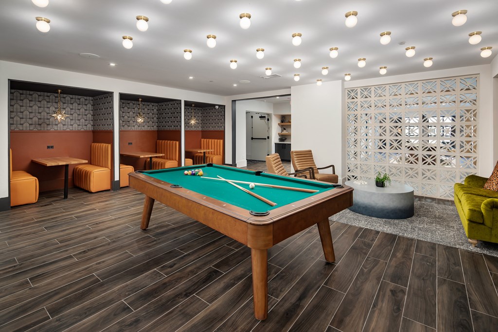 a community room with a pool table in the middle of it