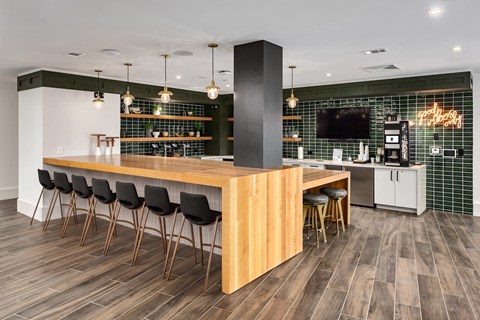 a kitchen with a bar and chairs and a television