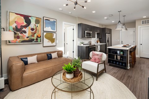 a living room and kitchen with a couch and a table