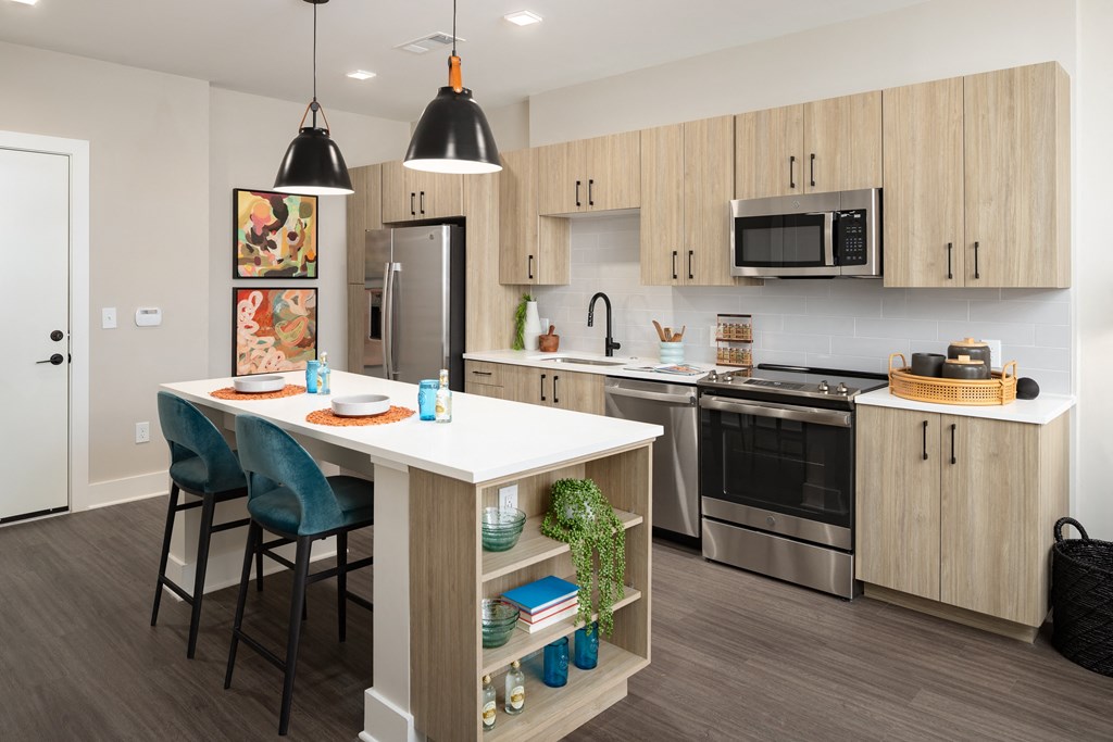 an open kitchen with a large island and stainless steel appliances