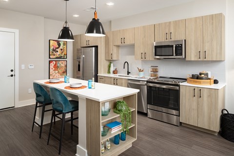 an open kitchen with a large island and stainless steel appliances