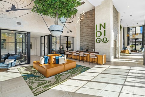 a lobby with a couch and chairs and a large sign