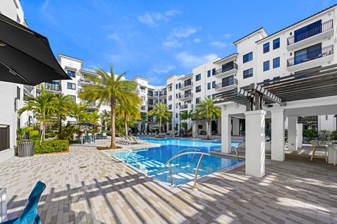 a swimming pool at a hotel with palm trees
