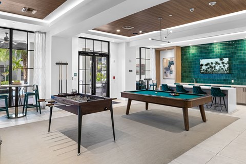 a billiards room with two pool tables and a bar