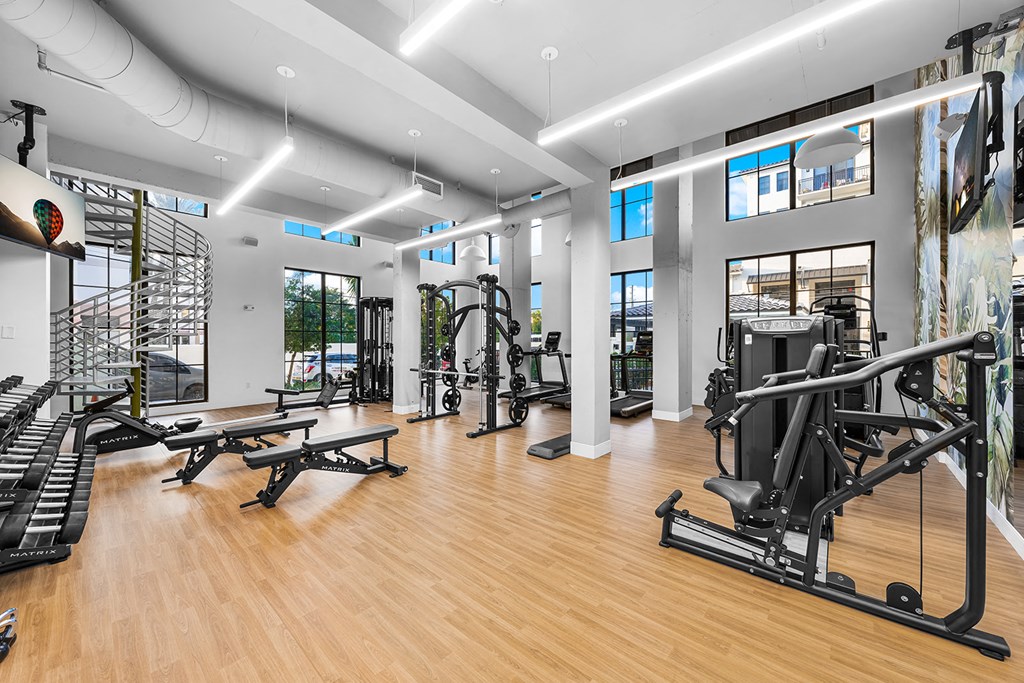 a gym with weights and other exercise equipment on a wooden floor
