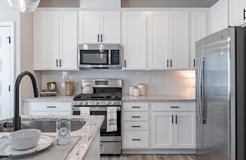 a kitchen with white cabinets and stainless steel appliances