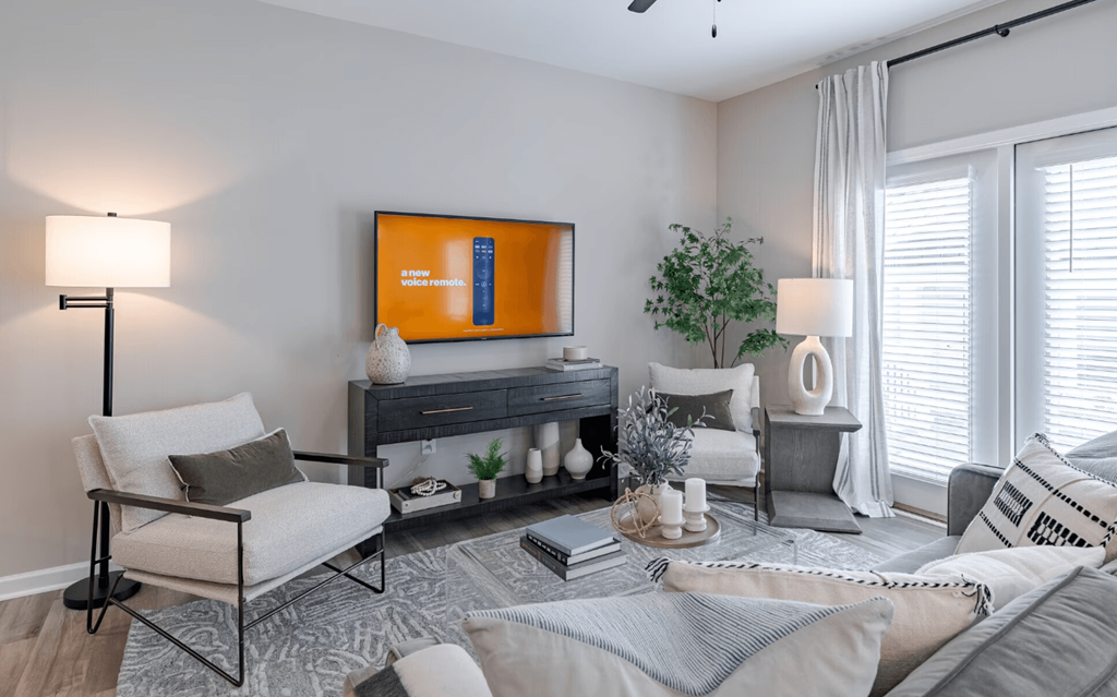 a living room with a couch and chairs and a tv