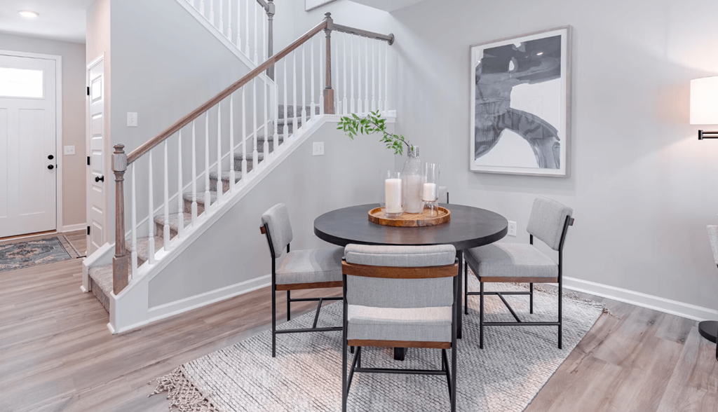 a dining room with a table and chairs and a staircase