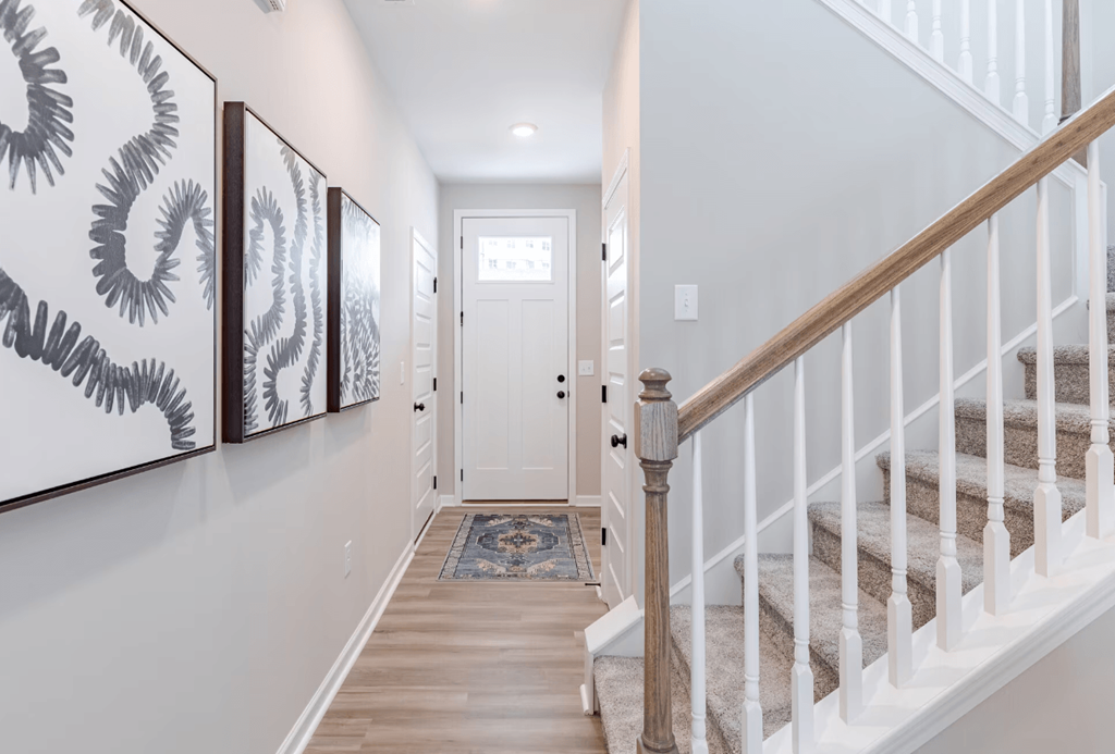 a hallway with stairs and a door to a white door