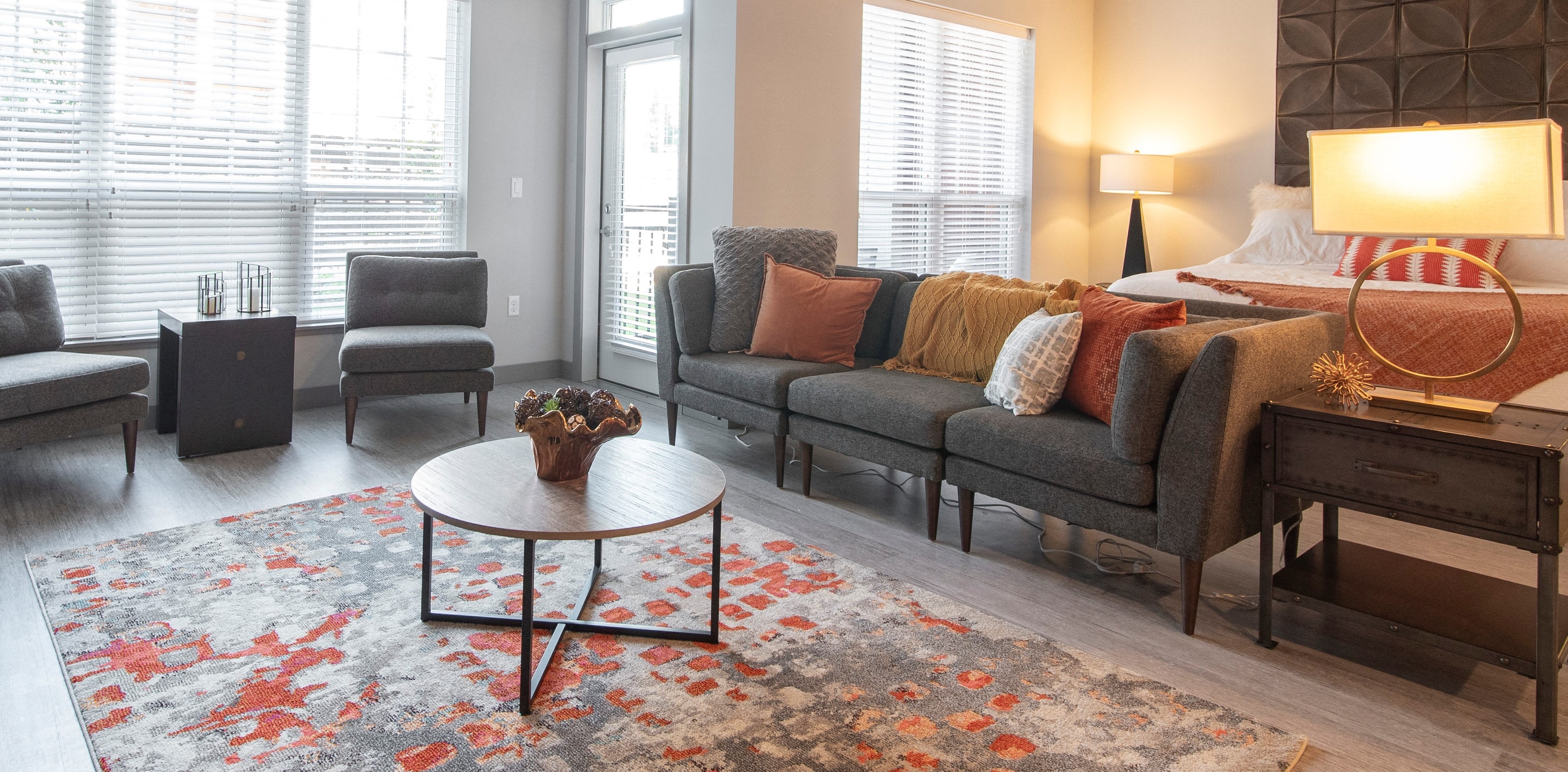 Decorated living area with coffee table, accent chairs, couch, and lamps.