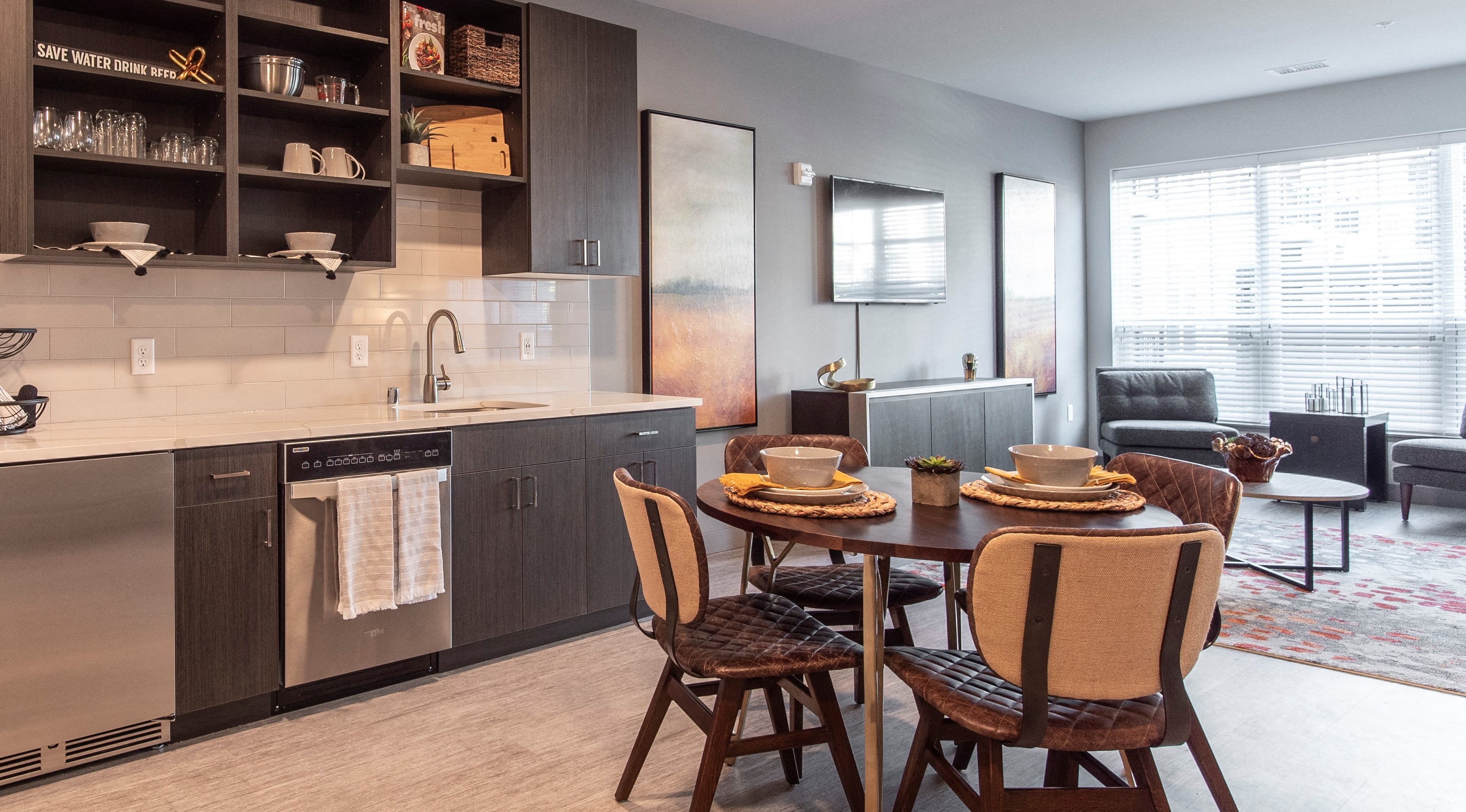 Kitchen with stainless steel appliances, dark cabinetry, and matching dining table in an apartment at Brookfield Reserve