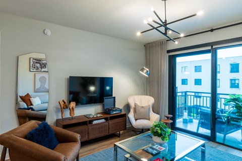 A living room with a brown leather chair and a glass coffee table.