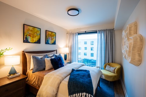 A bedroom with a large bed and a yellow chair.
