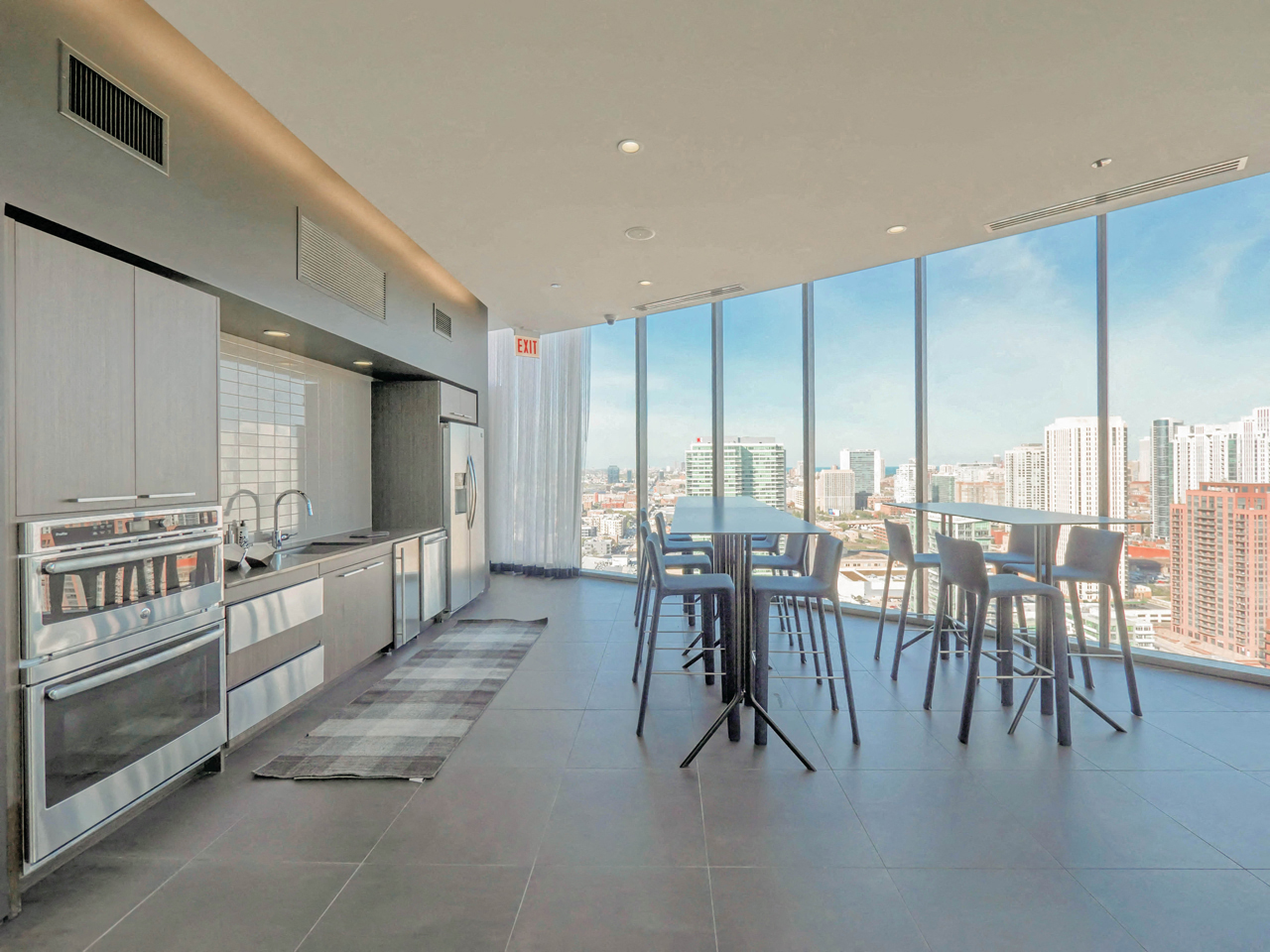 Rooftop lounge with kitchen area and barstool dining chairs