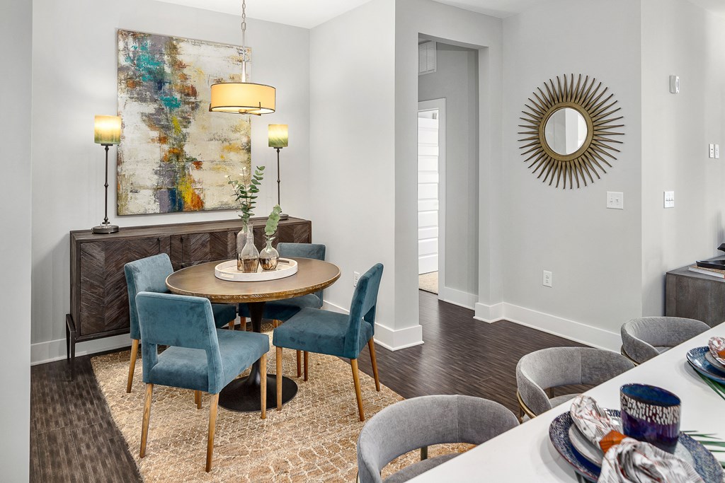 A dining room with a round table surrounded by chairs.