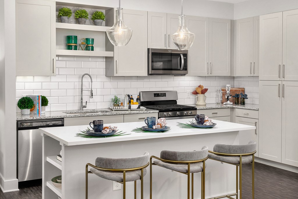 A modern kitchen with a white island and two barstools.