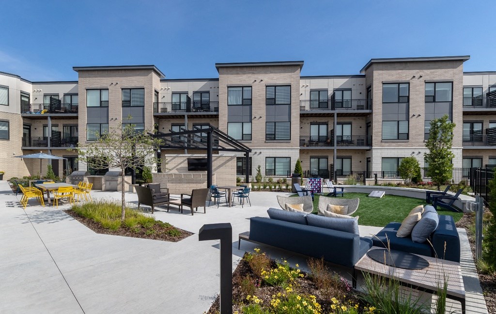 a rendering of a group of apartment buildings with patio furniture