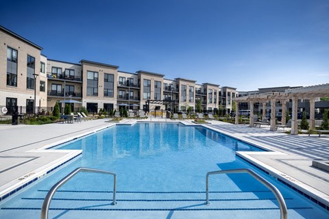 a large swimming pool with apartment buildings in the background