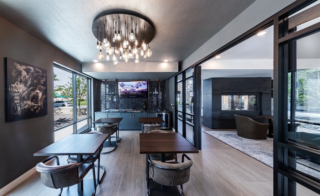 a dining room with tables and chairs and a view of a living room