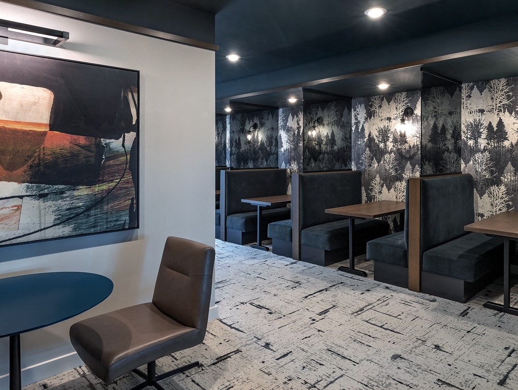 a dining room with tables and chairs and a painting on the wall
