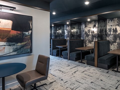 a dining room with tables and chairs and a painting on the wall