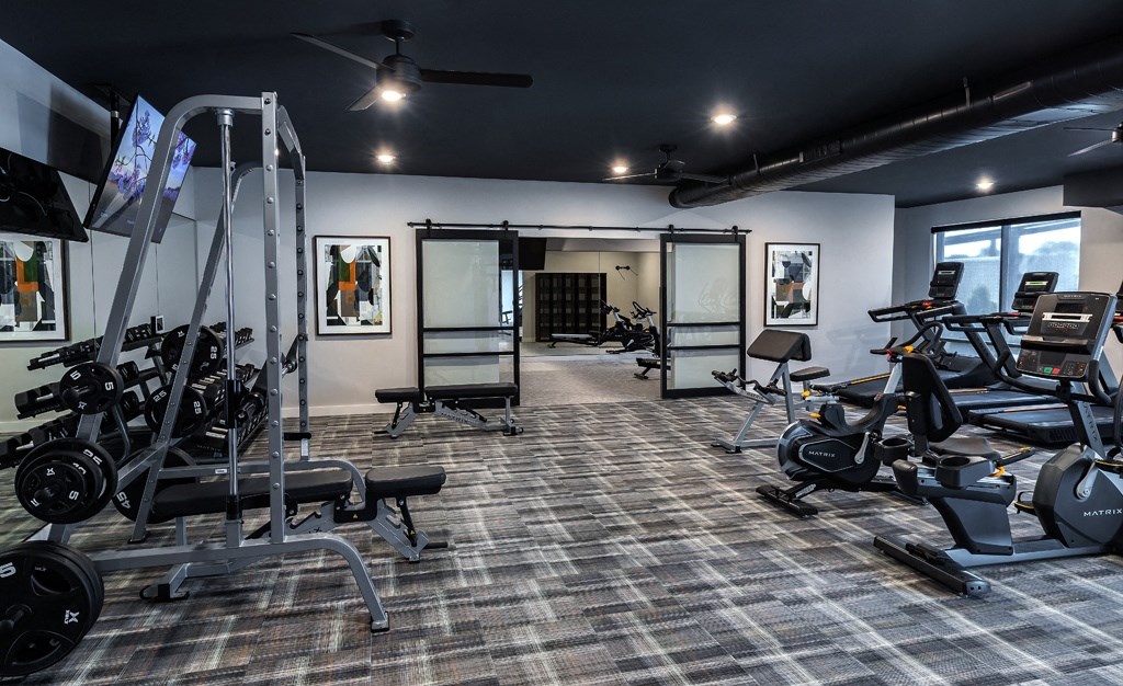 a fitness room with bikes and a wall of striped ceilings