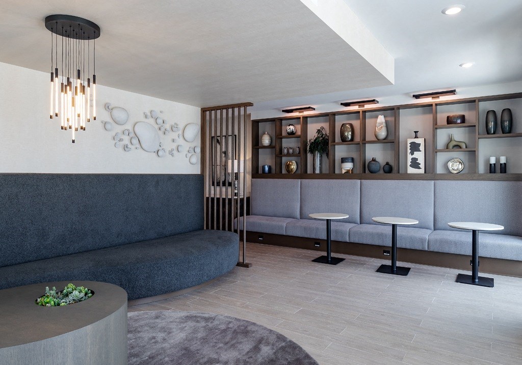 a lobby with couches and tables and a wall with shelves