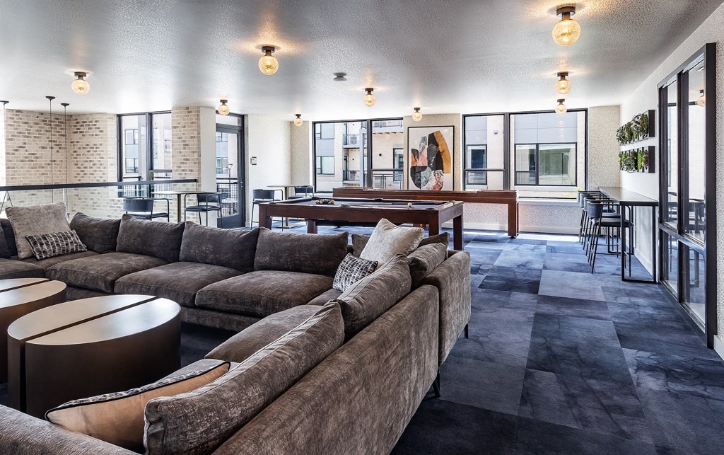 a large living room with couches and tables and a pool