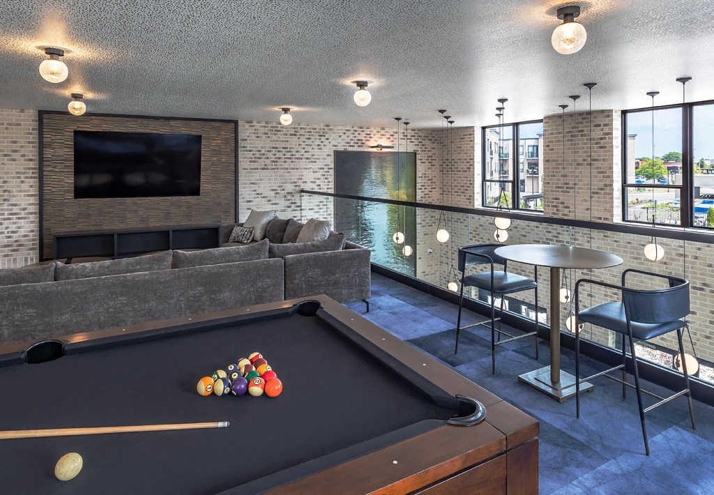 a living room with a pool table and a television