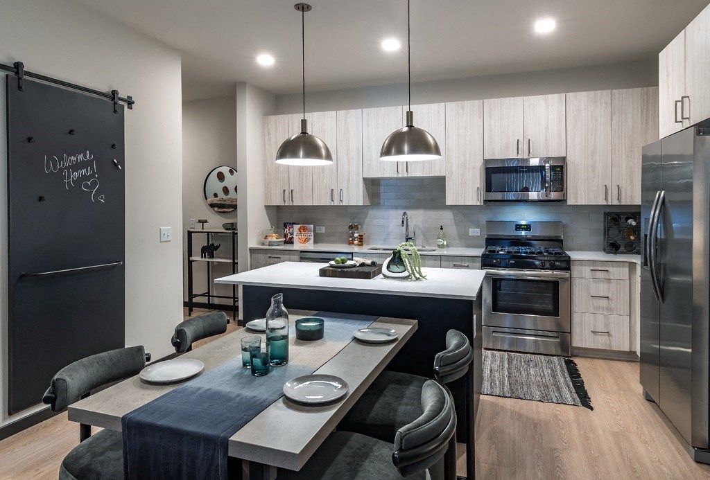 a kitchen and dining room with stainless steel appliances and a table