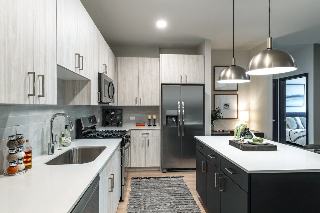 a black and white kitchen with stainless steel appliances and white counters