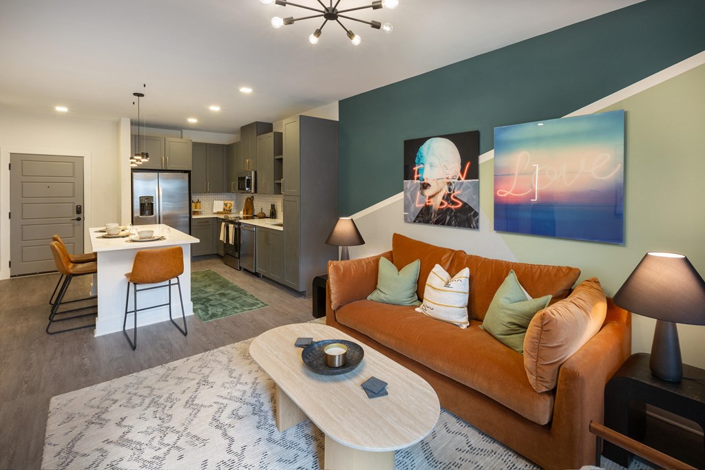 a living room with an orange couch and a kitchen with a table and chairs