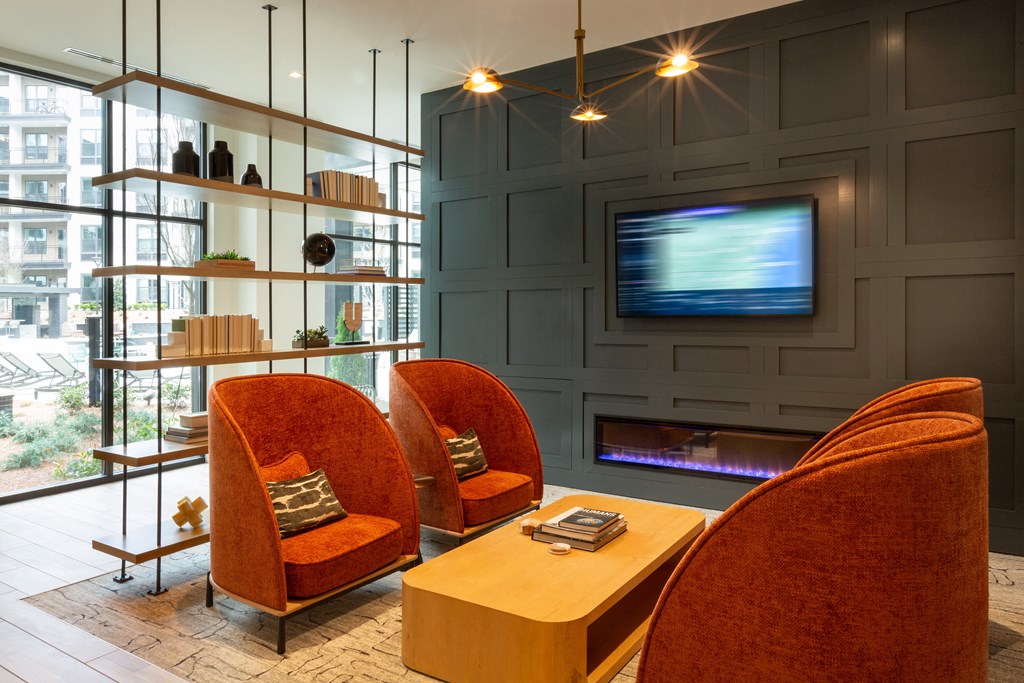 a living room with two orange chairs and a television