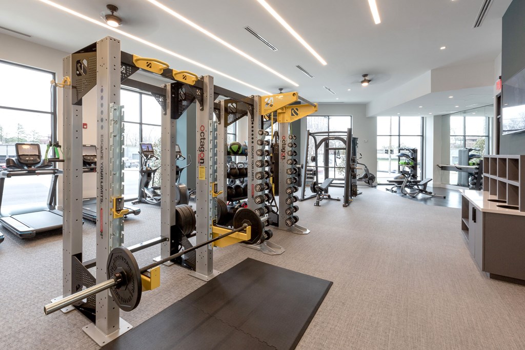 a gym with weights and other equipment in a building with windows