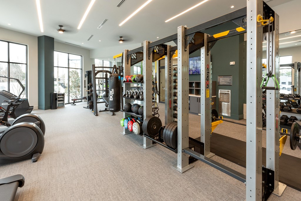 a gym with weights and other equipment in a building with windows