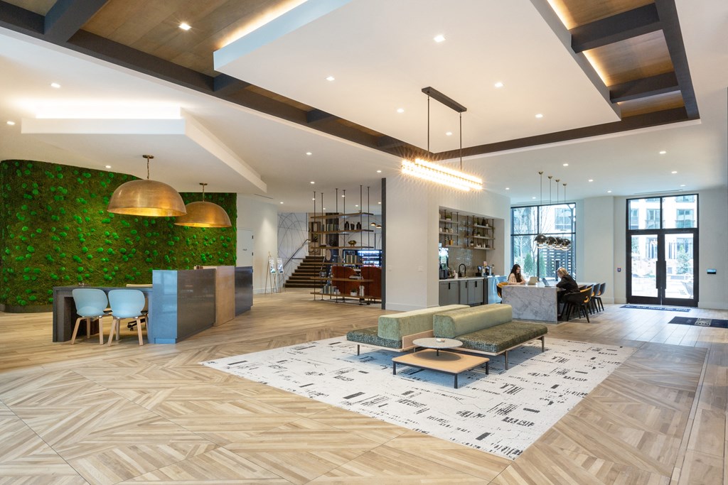 a reception area with a green wall and a lobby with couches and chairs